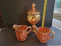 Golden carnival glass candy jar with lid standing next to measuring tape showing 11 inch height