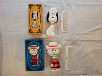 Photo of Avon Peanuts child brush and comb sets featuring Snoopy and Charlie Brown, with original boxes.