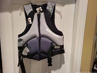 Front view of the Body Glove life jacket showing the zipper, logos, and adjustable black straps with buckles.