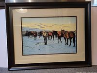 Framed limited edition print showing rural winter scene with person and horses, signed by artist.