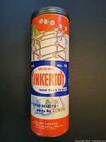 Photo of metal cylindrical container with colorful vintage Tinkertoy graphics and text