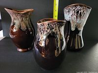 Overview of three BC Ceramics pottery pitchers showing dark brown glaze with lighter textured drip glaze on rims.