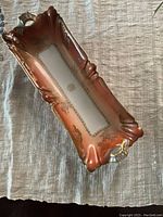 Top-down photo of antique Limoges Haviland & Co rose-colored porcelain serving dish with gold accents showing overall shape and condition.