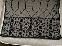 Full view of the sheer black shawl showing the beaded border design and scalloped edges.