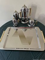 Full espresso set displayed on the tray, showing large and smaller espresso makers, sugar bowl, creamer, and tray with gold handles.