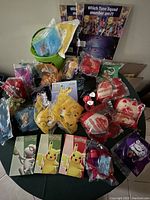 Multiple unopened McDonald's promotional toys in plastic packaging, along with Pokémon collectible card packs visible in front.