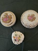 Overview of three vintage porcelain containers including two round painted Limoges-style boxes and one floral 3D flower figurine trinket container.