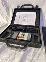 Open black plastic carrying case showing the Kleton anemometer device with attached wired fan sensor and user manual inside case lid.