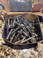 Photo of the open box showing about 70 metal sleeve anchors inside.