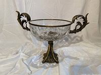 Front view of the antique bronze and glass centrepiece showing the clear glass bowl and ornate bronze handles shaped with leaf designs.