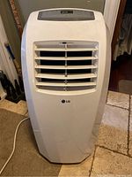 Front view of white LG portable air conditioner showing louvers and LG logo
