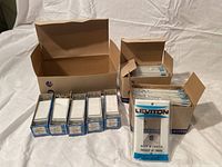 Photo shows 10 brand new Leviton light switches and covers in blue and white boxes, some boxes open showing white rocker switches.