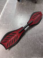 RipStik caster board top view showing red deck with grip patterns and RipStik branding.
