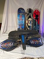 Photo shows three skateboards with wheels set vertically against a white background, and one skateboard deck lying flat without wheels, plus a Sole Skate on the floor.