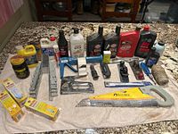 Photo of various motor oils, tools, joist hangers, saws and assembled tools on a countertop.
