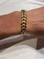 Bracelet shown on wrist from top view highlighting the linked gold plated leaf-shaped design.