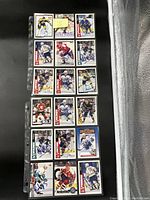 Photo showing 15 of the NHL hockey cards in plastic sleeves, featuring different players, some with visible autographs.