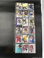 Photo showing 18 signed hockey cards in clear plastic sleeves in a binder sheet