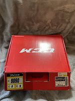 Top view of the closed red CCM skate box with size label 9.5D and model 9090 Tac SR on box sides.