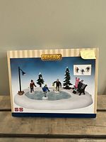 Front packaging showing Lemax Holiday Hockey animated set with figures on ice rink and accessories