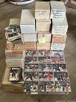 Wide image showing multiple boxes labeled with various baseball card years and series and loose cards.
