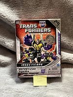 Front of box showing the Transformers Universe Insecticons set with the 25th Anniversary commemorative label and Decepticon logo.