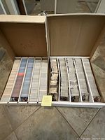 Two large white cardboard boxes filled with neatly arranged sports cards in multiple sections inside each box, showing mostly hockey cards.