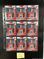Front view of nine identical Connor McDavid rookie cards featuring him in Edmonton Oilers uniform with National Hockey Card Day branding.