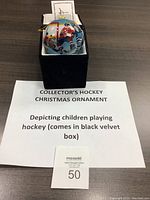 Collector's hockey Christmas ornament in black velvet box with white fabric lining, showing label and display setup.