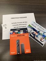 Top view of Amazon Fire TV Stick 4K Max package with supporting documents outlining the Firestick package contents including 6 months IPTV service and setup support.