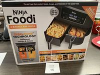 Front of boxed unit showing Ninja Foodi branding, DualZone baskets and fries