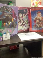 Three boxed jigsaw puzzles together: Enchanted Waters, When Dreams Come True, Santas Little Friends with title cards visible