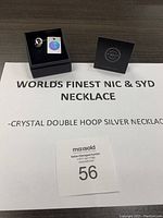 Photo of necklace box with authenticity tag and auction lot number