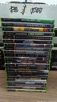 Stack of 23 original Xbox game cases, titles include NASCAR Heat 2002, Tom Clancy's Splinter Cell, and others lined up.