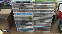 Photo showing the full stack of 54 Wii game cases in white standard Wii cases with readable titles including Michael Jackson, Just Dance, Wii Fit and more.