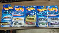 Photo of 10 Hot Wheels cars still in original packaging, displaying a variety of models and colors.