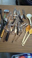 Top view of various kitchen utensils and cutlery spread on a table