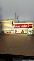 Full view of the Knickerbocker Beer lighted sign showing the text and clock.