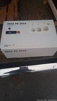 Box of Ikea PS 2014 lamp with printed label showing product details and year 2014.