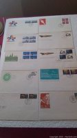 Top-down photo showing 10 first day cover envelopes arranged in grid. Various Canadian stamps and postmarks visible.