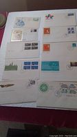 Top-down view of ten First Day Cover envelopes arranged on a surface showing various stamps and postmarks