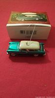 Photo showing the teal and white 1955 Chevy Nomad Wagon ornament with hanging string next to original Hallmark box.
