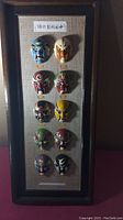 Full view of the framed oriental mask face painting display showing all 10 masks in two vertical columns.
