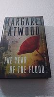Photo of the book cover showing the title 'The Year of the Flood' by Margaret Atwood with a large red leaf illustration.