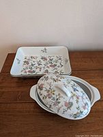 Front view of small casserole dish with lid and rectangular serving bowl, showing floral pattern and white fine china