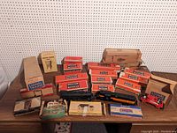 Overall display of multiple boxed and loose Lionel trains and kits on tabletop