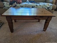 Front-side view of Ethan Allen solid wood coffee table showing rectangular top and turned legs