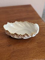 Top and side view showing the seashell shape and gold trim on the candy dish.