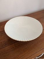 Top view showing the white fluted bowl with detailed ridges and gold trim around the edge.