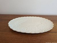 Oval Lenox serving platter with embossed leaf and floral details, side view showing scalloped gold-trimmed edge